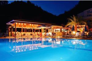 a swimming pool at night with a restaurant at Nobile Boutique Hotel in Agios Gordios
