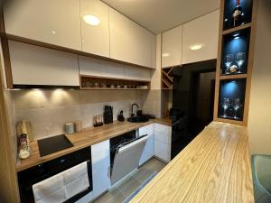 a kitchen with white cabinets and a counter top at Violet deluxe in Niš