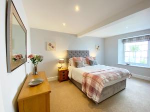 a bedroom with a bed and a table and a mirror at Sovereign House Luxury Apartment in Torquay
