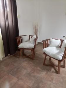 2 sillas con cojines blancos en una habitación en Aero en El Palomar