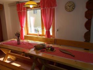 Zimmer mit einem Tisch, einer Uhr und einem Fenster in der Unterkunft Drevenica 66 in Ždiar
