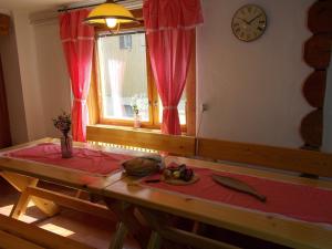 Habitación con mesa, reloj y ventana en Drevenica 66, en Ždiar
