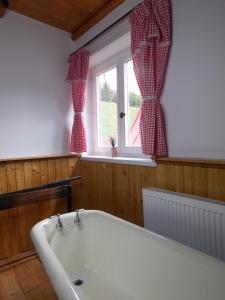 una bañera en un baño con ventana en Drevenica 66, en Ždiar 44 fotos más