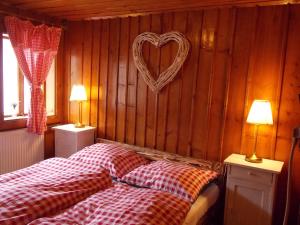 1 Schlafzimmer mit 2 Betten mit einem Herz an der Wand in der Unterkunft Drevenica 66 in Ždiar