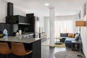 a kitchen and living room with a couch at Oasis Penthouse Maspalomas in Maspalomas