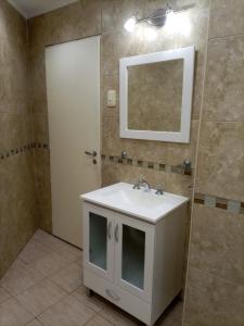 uma casa de banho com um lavatório branco e um espelho. em Aero (a 8 cuadras del Colegio Militar de la Nación) em El Palomar