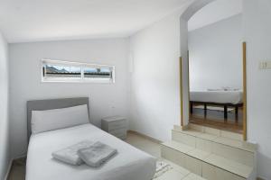 アロナにあるApto Vistahermosa 3 Bed and Poolのベッドと鏡のある白い寝室 +21枚の写真