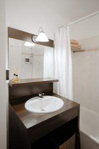 a bathroom with a sink and a mirror at NeuvaRoom in Montévrain