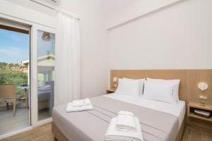 a bedroom with a large bed and a balcony at Villa Riza Sun by Villa Plus in Katastárion +12 photos