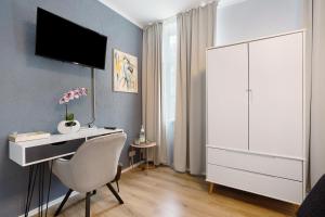 een slaapkamer met een bureau en een tv aan de muur bij Appartmenthaus - Wohnung C in Plauen