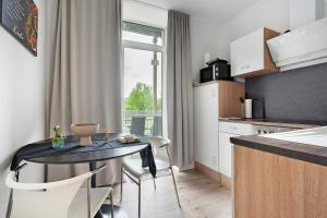 uma cozinha com uma mesa e cadeiras numa cozinha em Appartmenthaus - Wohnung A em Plauen