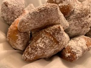 una pila de donuts cubiertos de azúcar sentados en un plato en Creole Dame Bed & Breakfast Inn, en Sumter
