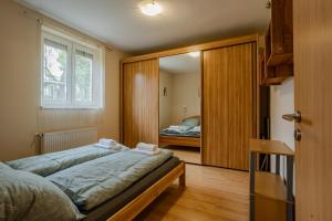 a bedroom with a bed and a door with a mirror at Six Corners Sunny Corner Apartment with Terrace in Pécs
