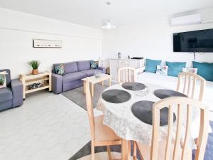 sala de estar con mesa y sofá púrpura en Apartment Concorde Sky Vista Mar, en Portimão