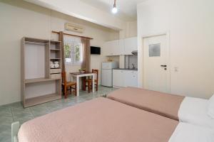 um quarto com 2 camas e uma cozinha com uma mesa em Giant Woman em Tsoutsouros