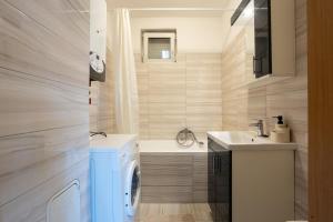 a bathroom with a washing machine and a sink at Six Corners Sunny Corner Apartment with Terrace in Pécs