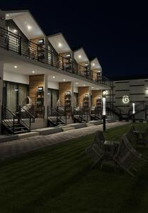 a building with two chairs in a yard at night at Tamimi Geshla Residency in Al Khobar
