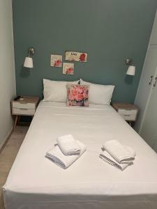 a large white bed with two towels on it at Drossinos Studios in Poros