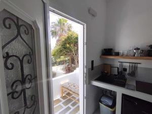 a door to a kitchen with a view of a patio at Maria's Garden in Antiparos +24 photos