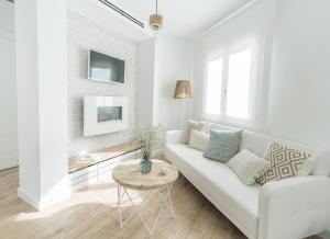 a white living room with a white couch and a table at Ático Chic Fontes junto a la Catedral in Murcia