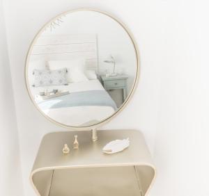 a mirror on a table with a bed in a bedroom at Ático Chic Fontes junto a la Catedral in Murcia