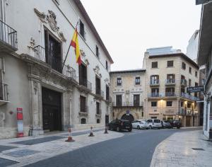 una calle con una bandera en el lateral de un edificio en Ático Chic Fontes junto a la Catedral en Murcia