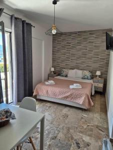 a bedroom with a bed and a brick wall at Drossinos Studios in Poros