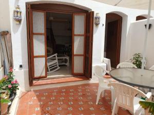 patio ze szklanymi drzwiami, stołem i krzesłami w obiekcie Estepona - Playa - 1 dormitorio con terraza solárium Mi17 w mieście Estepona