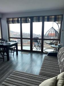 a living room with a view of a ferris wheel through the windows at Apartments Vista in Balchik
