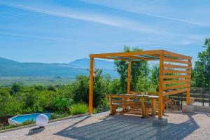 einem Holzpavillon mit einem Picknicktisch und einem Pool in der Unterkunft Sweet Cottage in Mostar