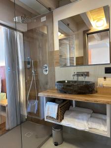 een badkamer met een wastafel en een glazen douche bij Studios Al Castello dei Limoni in Limone sul Garda