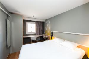 a hotel room with a bed and a desk at ibis Sisteron in Sisteron