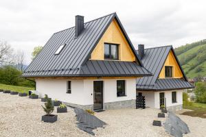a house with a black roof at Niebieska Turnia in Poronin