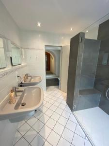 a bathroom with two sinks and a shower at Gasthaus Wollscheid in Trier