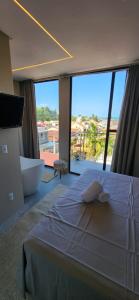 a bedroom with a large bed and a large window at Casa Arrô - Pousada Boutique in Itajaí