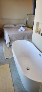a bathroom with a bath tub and a bed at Casa Arrô - Pousada Boutique in Itajaí +53 photos