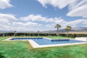 een zwembad in een tuin met palmbomen bij Relaxation, GOLF and Beach in Caleta De Velez