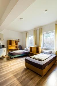 2 Betten in einem großen Zimmer mit Holzböden in der Unterkunft Apartmenthaus in Chemnitz für Monteure in Chemnitz