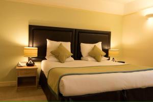 une chambre d'hôtel avec un grand lit et deux lampes dans l'établissement The Limes Hotel, à Stratford-upon-Avon