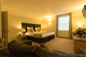 une chambre d'hôtel avec un lit et un canapé dans l'établissement The Limes Hotel, à Stratford-upon-Avon