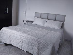 1 dormitorio con 1 cama grande y edredón blanco en Apartamento en Salvador bahía com ar condicionado, en Salvador