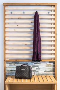 eine Handtasche auf einer Holzbank vor einer Wand in der Unterkunft Hotel Christine in Eisenberg