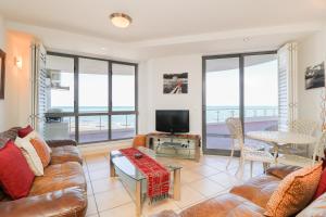 a living room with a couch and a table at 506 Hibernian Towers Luxury Self Catering Apartment Strand Cape Town South Africa in Cape Town