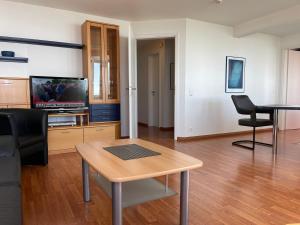een woonkamer met een tafel en een televisie bij Apartment 123 in Wilhelmshaven