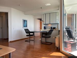 een keuken en een woonkamer met een tafel en stoelen bij Apartment 123 in Wilhelmshaven