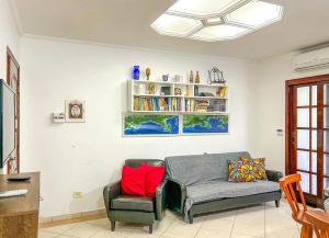 - un salon avec un canapé et une chaise dans l'établissement Incrivel casa a 200m da Praia da Enseada Bertioga, à Bertioga