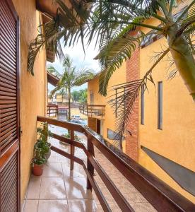 een balkon met een houten leuning naast een gebouw bij Incrivel casa a 200m da Praia da Enseada Bertioga in Bertioga
