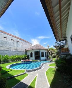a swimming pool in the yard of a house at THE SUN BALI VILLA’S in Kuta