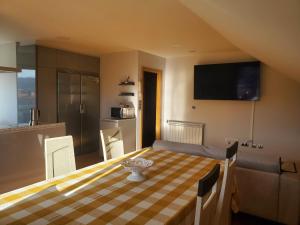 a room with a table and a kitchen with a television at ÁTICO EXCEPCIONAL TRANQUILO En LA PLAYA in Arcade