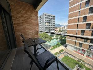 una mesa y una silla en un balcón con vistas en Sam's Apartments 2 - Tirana, en Tirana
